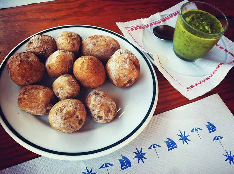 Patatas arrugadas con una salsa verde.