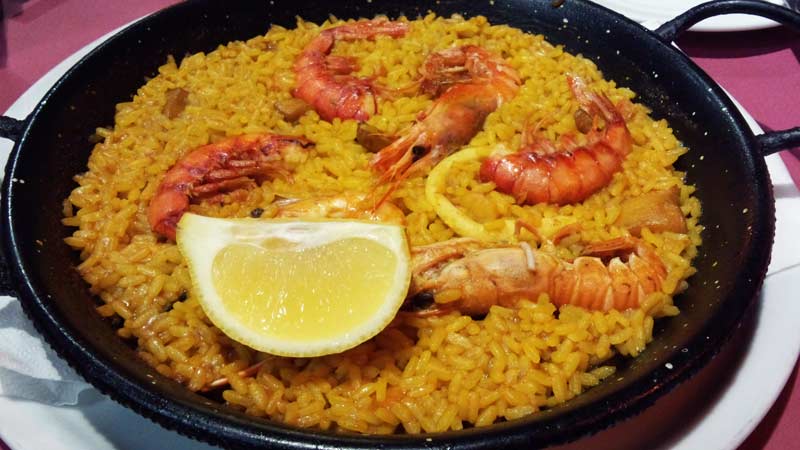 paella negra con arroz que tiene langostinos y sepia