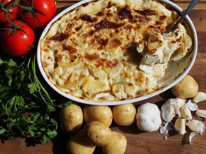 Plato de patatas al horno con queso gratinado.