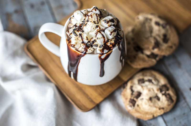 taza con pudin de cafe, nata y sirope de chocolate
